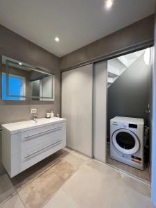 a bathroom with a sink and a washing machine at Hytte på sørlandet in Kristiansand