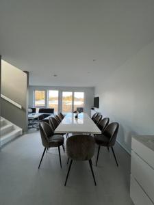 a dining room with a white table and chairs at Hytte på sørlandet in Kristiansand