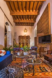 sala de estar con sofá, mesas y chimenea en Casa Palacio Rincón de la Catedral, en Toledo