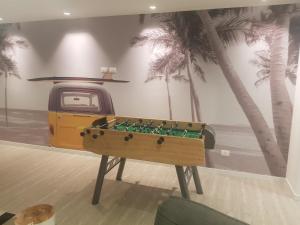 a pool table in a room with palm trees at Ocean Drive Country - Punta del Este in Punta del Este