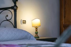 una lámpara sentada en una mesa junto a una cama en Firenze Rentals Mini Suite Corso, en Florencia