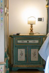 une commode verte avec une lampe au-dessus dans l'établissement Firenze Rentals Mini Suite Corso, à Florence