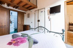 une chambre avec un lit avec une fleur dessus dans l'établissement Firenze Rentals Mini Suite Corso, à Florence