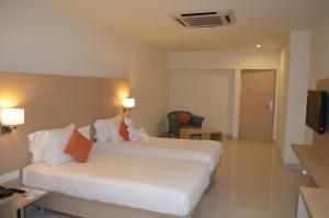 a hotel room with two beds and a television at Regency Tiruttani by GRT Hotels in Tiruttani
