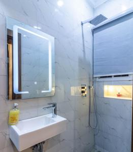 ein weißes Badezimmer mit Waschbecken und Spiegel in der Unterkunft Oslo Apartment in Abuja + 4 Fotos