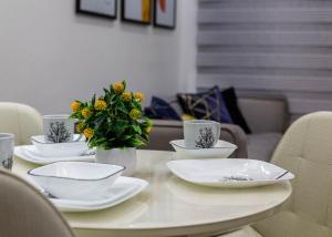 a table with white plates and yellow flowers on it at Oslo Apartment in Abuja +4 photos