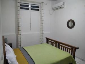 - une chambre avec un lit vert et une fenêtre dans l'établissement Appartement entier à Terre de Haut - Chez Odile, à Terre-de-Haut