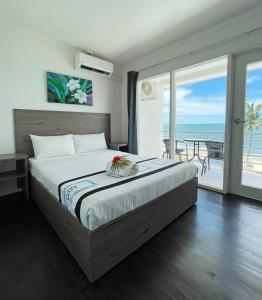 a bedroom with a bed with a view of the ocean at Sailors Beach Fiji in Nadi
