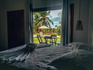um quarto com uma cama e vista para um pátio em Chalés Ed Moitas em Praia de Moitas