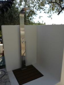 a bathroom with a shower in a white wall at CASA MARE e TRAMONTO in Monte Marzeddu