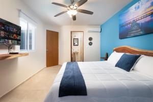 a bedroom with a large bed with a ceiling fan at Villa Sofia Boutique Hotel Cancun in Cancún