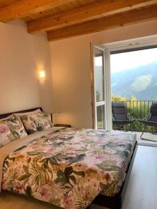 a bedroom with a bed and a balcony with a view at Casa Vista Monte Rosa in Toceno