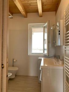 a bathroom with a sink and a toilet and a window at Casa Vista Monte Rosa in Toceno