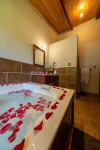 uma casa de banho com uma grande banheira com rosas vermelhas em Hacienda Grande Hotel em Quetzaltenango