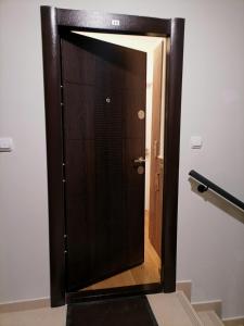 uma porta de elevador de madeira num quarto com uma escada em APARTMAN ANA em Niš