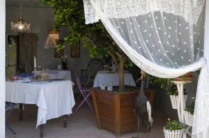 a dining room with two tables and a tree at Ca'Bevilacqua Bed&Breakfast in Bertinoro