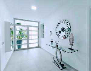 a white hallway with a glass table and a mirror at Elegante y moderna Villa Miami in Adeje