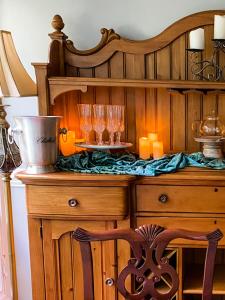 a wooden counter with glasses and candles on it at Colonial Gardens B & B in Williamsburg