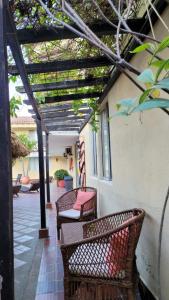 a patio with two wicker chairs under a pergola at Najhomi Beach in Santa Marta