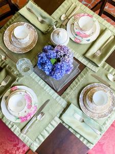 a table with plates and a vase of flowers on it at Colonial Gardens B & B in Williamsburg +45 photos