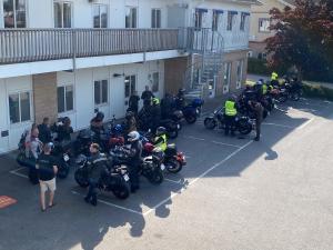 um grupo de pessoas em motocicletas estacionadas fora de um edifício em De la Gardie Park Vandrarhem Hostel em Lidköping