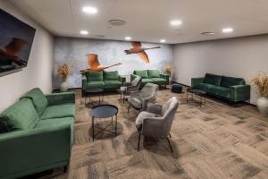 a waiting room with green couches and chairs at Scandic Kolding in Kolding