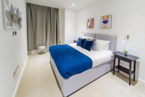 a bedroom with a large bed with blue pillows at Absolute Stays at The Ziggurat - St Albans-High Street- Near Luton Airport - St Albans Abbey Train station -Close to London- Harry Potter World - The Odyssey Cinema-Contractors -London Road-Business-Leisure in Saint Albans