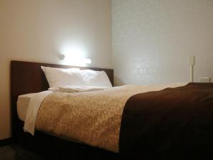 Postel nebo postele na pokoji v ubytování Hamamatsu Station Hotel