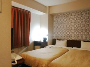 Postel nebo postele na pokoji v ubytování Hamamatsu Station Hotel