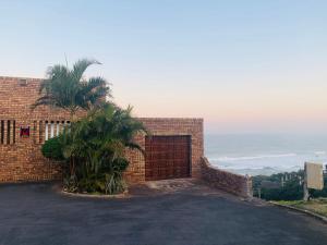 a brick building with a gate and a palm tree at Hansmeyer Hill - 5 Bedroom House in Margate