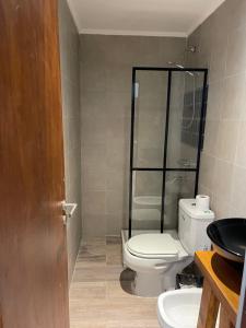 a bathroom with a toilet and a glass shower at ApartaHotel LaCatedral in Reconquista