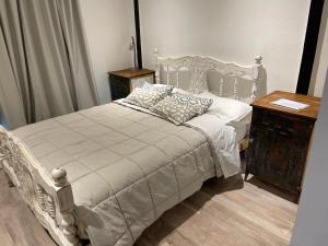 a bedroom with a white bed and a wooden table at ApartaHotel LaCatedral in Reconquista