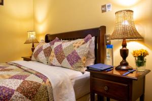 a bedroom with a bed and a table with a lamp at Hacienda Grande Hotel in Quetzaltenango