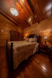 1 dormitorio con cama y techo de madera en Hacienda Grande Hotel, en Quetzaltenango