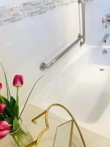 a bathroom with a tub and a vase of flowers at Madison LES Hotel in New York +44 photos