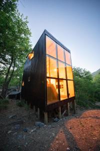 ein schwarzes winziges Haus auf einem Holzständer in der Unterkunft Andrómeda Lodge in Las Trancas