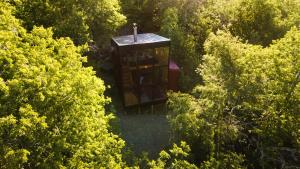 an overhead view of a small building in the middle of trees at Andrómeda Lodge in Las Trancas