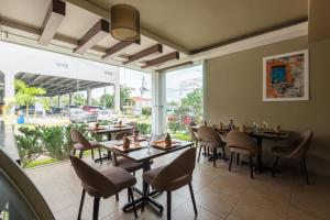 a restaurant with tables and chairs and a large window at Isabella Boutique Hotel in San Pedro Sula