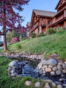a creek in front of a log cabin at Lodge at Sandpoint in Sandpoint