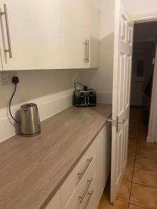 a kitchen with white cabinets and a toaster on the counter at Smith House in Scunthorpe