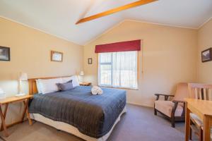 a bedroom with a bed and a window at Eglinton Valley Camp in Te Anau Downs