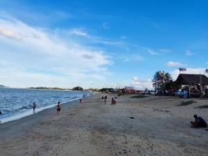 a group of people on a beach near the water at AYUNI HOMESTAY KUALA BESUT TERENGGANU in Kuala Besut