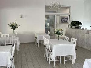 een eetkamer met witte tafels en witte stoelen bij Garnì Stella Marina in Cervia