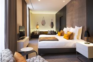 um quarto de hotel com uma cama grande e um sofá em Hotel D - Strasbourg em Estrasburgo