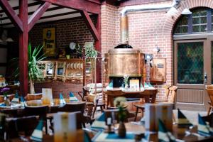 a restaurant with tables and a large pot on the wall at Braugasthof Papiermühle in Jena