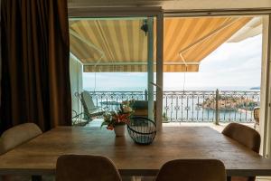 a dining room table with a view of a balcony at Villa Edelweiss in Sveti Stefan