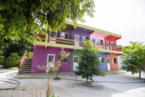uma casa colorida com uma varanda em cima em Pousada Recanto do Galo em Santa Cruz Cabrália