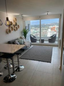 a living room with a table and a large window at Departamento de lujo Estacionamiento privado y cocina integral in Viña del Mar