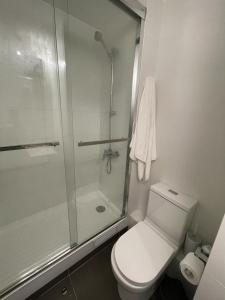a white bathroom with a shower and a toilet at Departamento de lujo Estacionamiento privado y cocina integral in Viña del Mar
