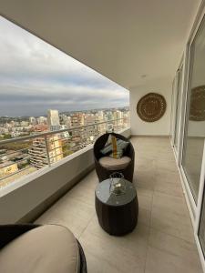 a balcony with a table and a chair and a window at Departamento de lujo Estacionamiento privado y cocina integral in Viña del Mar